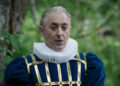 Alan Cumming talking while dressed in an extravagant outfit on The Traitors Season 3. .