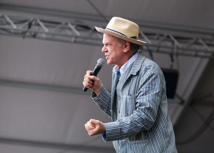 John C. Reilly takes the stage to introduce performers during the final act on Sunday, July 27 at the Newport Folk Festival.