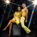 Dr Punam Krishan and Gorka Márquez for Strictly Come Dancing in yellow outfits on a glitzy star background.