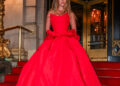 Sydney Sweeney wearing a dramatic red ball gown while posing on the steps outside