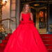Sydney Sweeney wearing a dramatic red ball gown while posing on the steps outside