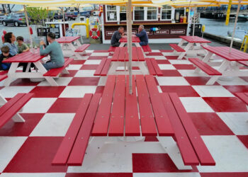People enjoy lunch atop the colorful tables of The Whale's Tail Clam Bar on New Bedford's waterfront.