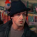 Sylvester Stallone's Rocky inside pet store wearing his black hat and black leather jacket.