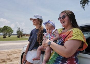 Fans Emma Touchstone, 17, left, and Kelsey Heath with her four-month-old daughter Maggie Fields wait for reality television star Todd Chrisley walks out of the Federal Prison Camp, Wednesday, May 28, 2025, in Pensacola, Fla. (AP Photo/Dan Anderson)