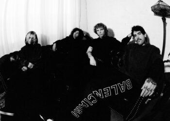 Members of pop punk band Beauty School Drop Out sit in a minimalist room posting for the camera