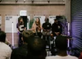 a panel of people sit on chairs in front of an audience