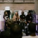 a panel of people sit on chairs in front of an audience