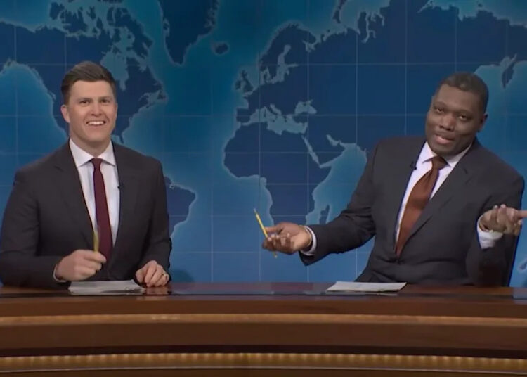 Colin Jost and Michael Che behind Weekend Update desk in SNL Season 50.