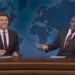 Colin Jost and Michael Che behind Weekend Update desk in SNL Season 50.