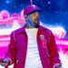 Will Smith wears red hat and jacket on stage.