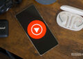 YouTube Music logo on smartphone, next to headphones and Nest Mini (2)