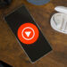YouTube Music logo on smartphone, next to headphones and Nest Mini (2)