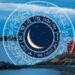 Collage of a lighthouse at night with the ocean in the background. An illustrated wheel of zodiac signs with a waning crescent moon in the middle sits tucked behind the rocks and lighthouse.