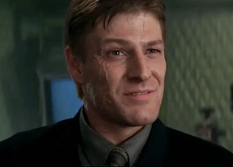 Sean Bean smirks while Famke Janssen watches in the background in Goldeneye.