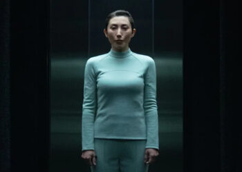 Gemma in light blue wardrobe standing in Testing Floor elevator in Severance Season 2 "Chikhai Bardo".
