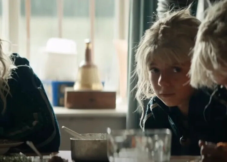 Spike sitting at table with Jimmy Cult members in 28 Years Later: The Bone Temple.