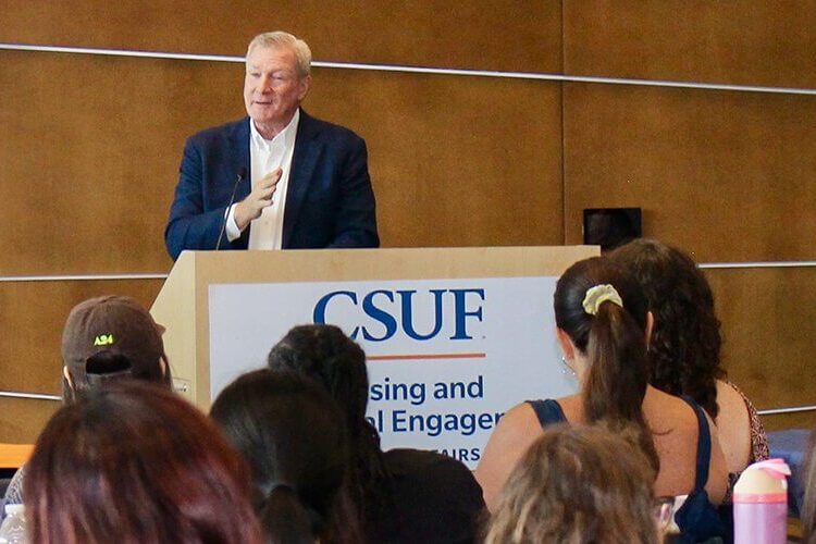 CSUF alum Tom Mehrmann speaks to a group of students.