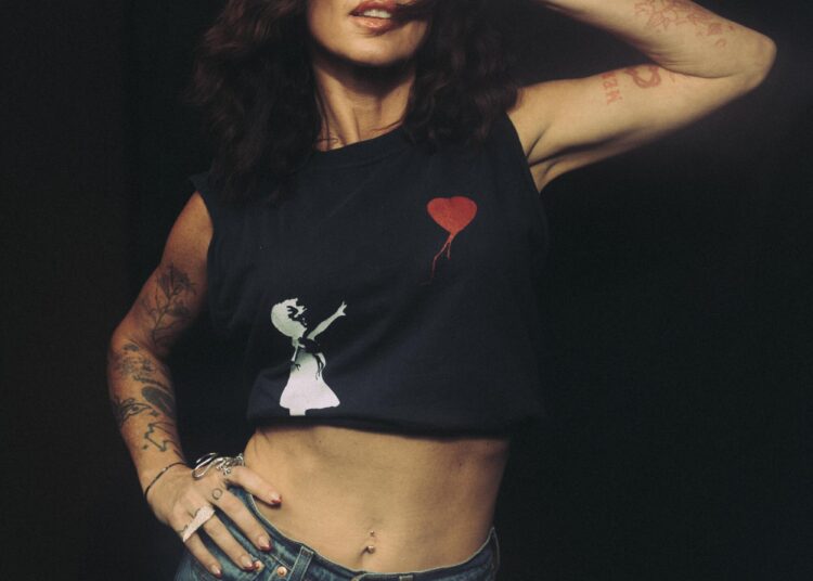 Amanda Shires standing in a cut-off shirt.