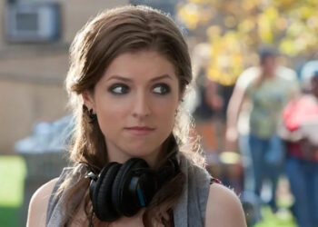 Anna Kendrick with headphones around neck in Pitch Perfect .