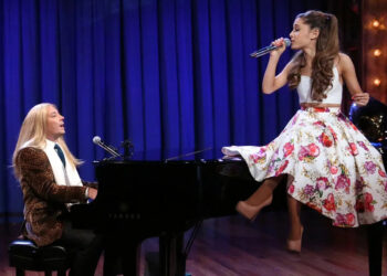 Ariana Grande sings on a piano that Jimmy Fallon in a blonde wig plays.