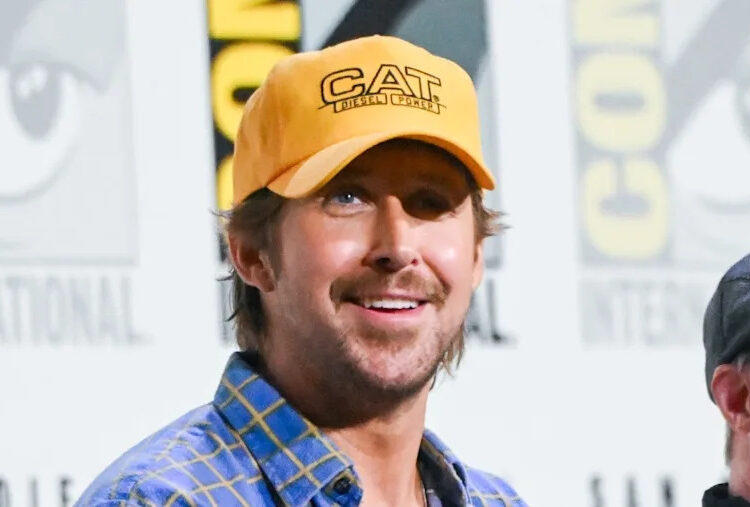 Ryan Gosling in a blue plaid shirt smiles at Comic-Con.