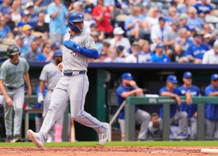Baseball player runs with a glove and helmet on