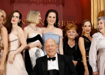 Raquel Cassidy, from back left, Sophie McShera, Laura Carmichael, Michelle Dockery, Lesley Nicol, Joanne Froggatt, Phyllis Logan and writer Julian Fellowes, front, pose for photographers upon arrival at the world premiere of the film 'Downton Abbey: The Grand Finale' on Wednesday, Sept. 3, 2025, in London. (Photo by Millie Turner/Invision/AP)