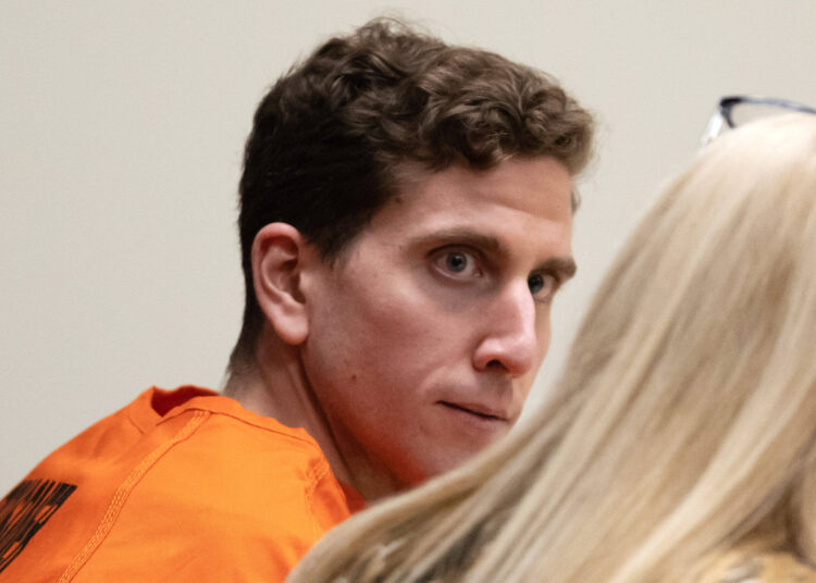 Bryan Kohberger in an orange prison jumpsuit, seated in court and looking to the side during a hearing.