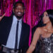 Offset and Cardi B pose together. Offset wears a suit and flashes a peace sign, while Cardi B is in a metallic dress, set against pink tinsel.