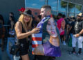 A man and woman stand smiling outside a record store.