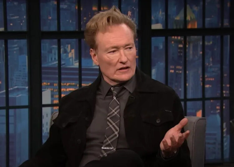 Conan O'Brien speaking with Seth Meyers on Late Night.