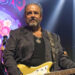 Raul Malo holds a guitar on stage during a concert.