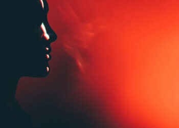 Portrait of beautiful woman lit by neon colored lights.