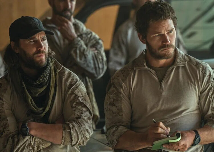 From left to right: Taylor Kitsch standing with his arms crossed and Chris Pratt writing on a notepad in The Terminal List: Dark Wolf. .