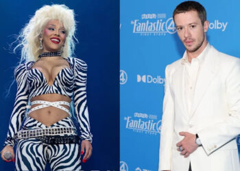 Zebra-outfit performer on stage; person in white suit at a blue event backdrop.