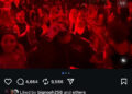 A crowded nightclub scene with people dancing under red lighting.