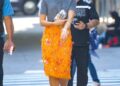 new york, ny dua lipa looks perfectly stylish wearing an orange gucci floral long skirt, mini fur grey shirt, silver heels, silver mini purse, clear bracelet, and sunglasses, taking a stroll in new york