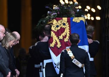 The coffin of the Duchess of Kent, draped in the Royal Standard, is carried into Westminster Cathedral as her husband the Duke of Kent and daughter Lady Helen Taylor bow their heads