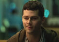 Dylan O'Brien sitting in a diner in Twinless.