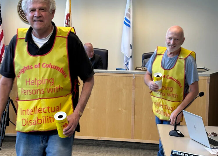 Knights of Columbus Spalding Council 427 members Jim Wygle (left) and Jerry Campen circulate through East Peoria City Council chambers during Tuesday's meeting to hand out Tootsie Rolls and get an early start on the Knights of Columbus 2025 Support Citizens with Intellectual Disabilities Tootsie Roll Drive.