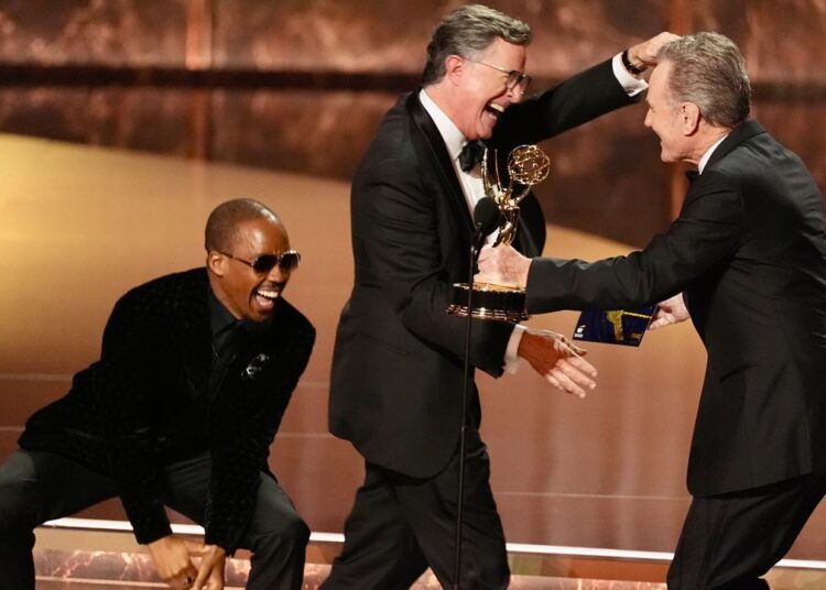 Bryan Cranston, right, presents the award for outstanding talk series to Stephen Colbert, left, for "The Late Show with Stephen Colbert" during the 77th Primetime Emmy Awards on Sunday, Sept. 14, 2025, at the Peacock Theater in Los Angeles. (AP Photo/Chris Pizzello)