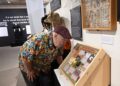 UC Davis alumnus and Vacaville Museum member Layton Damiano of Vacaville (he holds a bachelor's degree in creative writing from UC Davis), reads the Bohart Museum display on Insects that Use Ephemeral Resources at the Vacaville Museum. (Photo by Kathy Keatley Garvey)