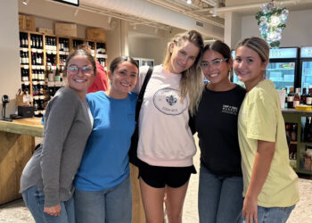 Claire Holt, center, poses with employees at Farm & Coast Market.