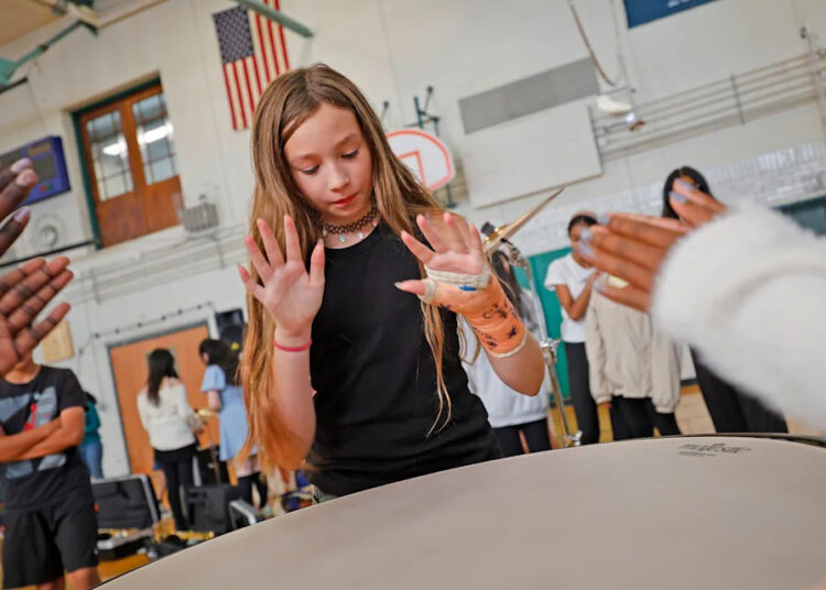 Students get their hands on a large timpani and tap it to see how it sounds. The Point Webster Middle School in Quincy received a grant from the Music Drives Us organization of $65,000 in musical instruments for the school band and music program on Tuesday, Sept. 9, 2025.