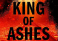 King of Ashes text from book cover over a red-tinted image of train tracks. .