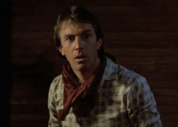 Kevin Costner as Jake wearing a bandana around his neck in a jail cell in Silverado.