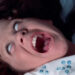 Linda Blair, as Reagan, screaming in agony as the demon takes over her body in The Exorcist (1973).