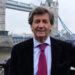 Melvyn Bragg standing by Tower Bridge
