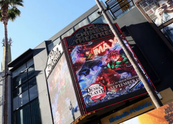A large IMAX theater marquee displays a