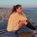Jennifer Lopez posted on Instagram in a cardigan, lace bloomers/skirt, and lace-up knee-high boots